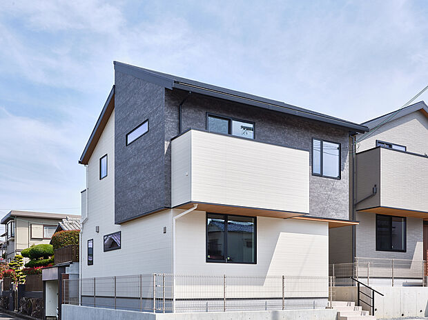 【1号地】濃淡ツートンのモダンな外観と張り出したバルコニーが印象的な2階建て。角地の開放感とプライバシーを両立させます。