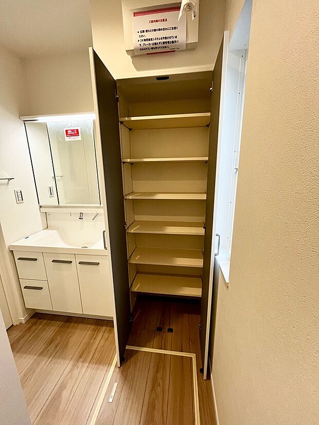 【洗面所】1号棟　シャワー付洗面化粧台、収納棚付き