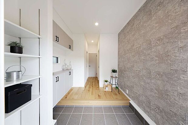 5号地モデルハウス
スムーズに出入り可能な引き戸を採用した玄関。右側にはマットな質感の石目調クロスを一面にあしらい、上質で落ち着いた空間に仕上げています。左側には可動棚を備えた土間収納を設置。