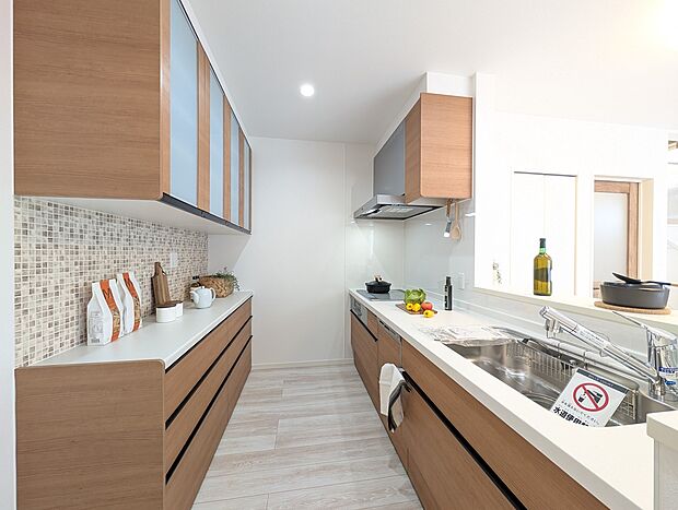 【【1号地】キッチン】家族とのつながりを大切にした対面式キッチンは、料理をしながら会話を楽しめる家族の温かさを感じる空間です。豊富な収納と使いやすい設備が整い、使いやすさとデザイン性を兼ね備えています。