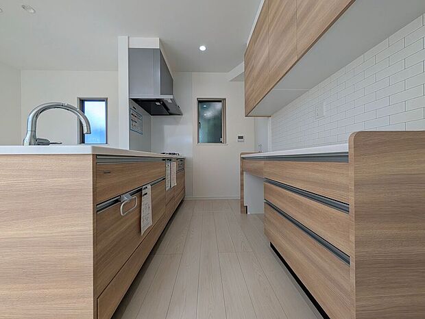 【【2号地】キッチン】システムキッチン、カップボード、床下収納など高い収納力が魅力のキッチンは、毎日使う場所をすっきりと保つことができて快適です。生活感を隠すこともできて来客時もばっちり。