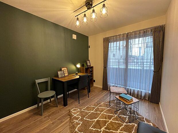 【【当社施工例】洋室】グリーンのアクセントクロスと、シンプルな床材を組み合わせたお洒落な洋室です。プロジェクターでクロスに映し出し、ご家族と映画を楽しむことができます。