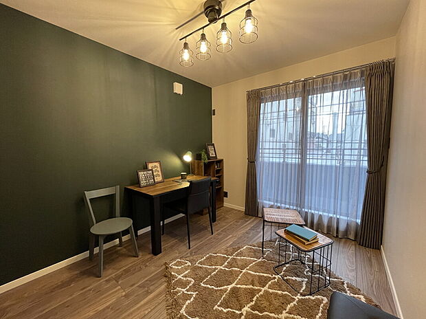 【【当社施工例】洋室】グリーンのアクセントクロスと、シンプルな床材を組み合わせたお洒落な洋室です。プロジェクターでクロスに映し出し、ご家族と映画を楽しむことができます。