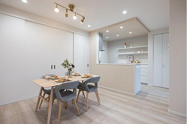 【【当社施工例】リビング】建具とキッチンの収納は白で統一され、シンプルかつ洗練された内装です。木目の家具やゴールドの照明など、お好きなインテリアを楽しめます。