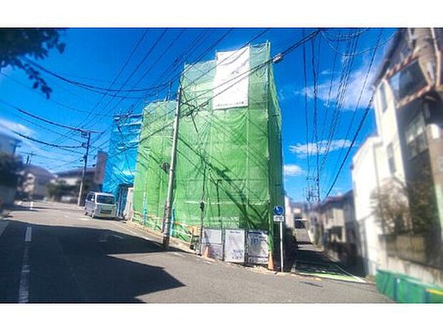 ■現地画像
正面がA号棟。広い道路の幅員は約6.9m