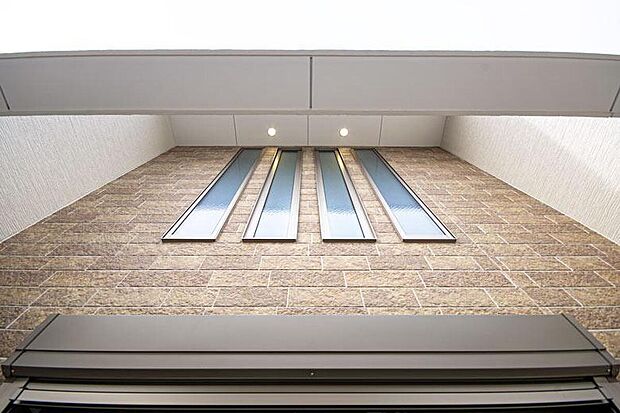 【【本分譲地に建築可能な建物プラン例】】縦長の窓と赤みのある外壁材が目を惹く佇まい。ダウンライトを壁側に寄せ、暗くなった時の見方にもこだわりました。《分譲地外:建物面積106.92m2、建物価格1920万円》