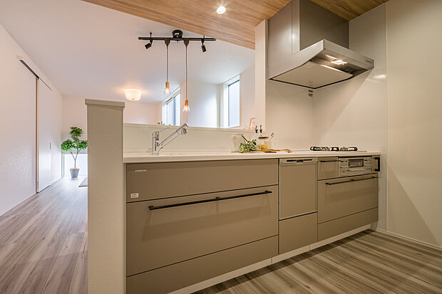 【【キッチン】】ビルトイン食器洗乾燥機やコンロを搭載したシステムキッチン。調理や下ごしらえを行うワークトップは、すっきりとしています。