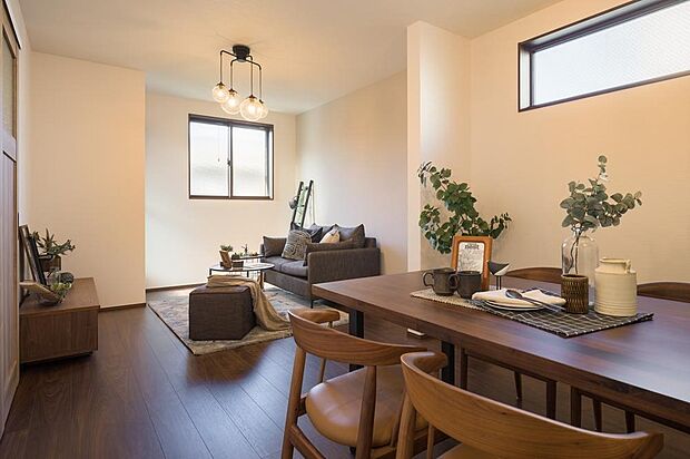 【【本分譲地に建築可能な建物プラン例】】トーンを抑えた床材が空間全体に落ち着きをもたらし、ご家族がゆったりとくつろげる団らんの場に仕上がっています。《分譲地外:建物面積102.66m2、建物価格2141万円》