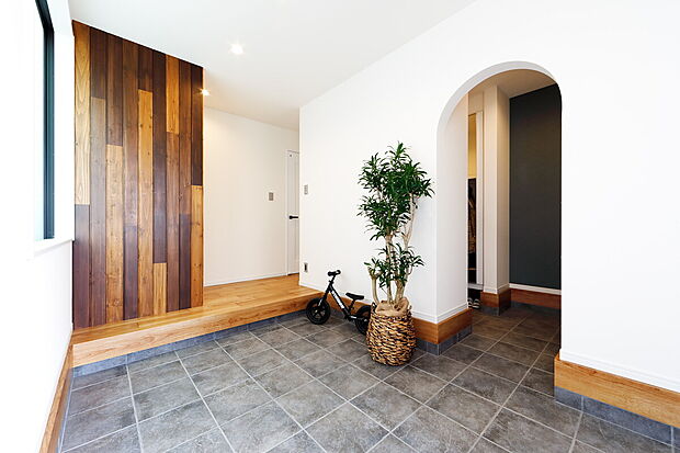 【玄関(当社施工事例)】広々とした玄関の横には通り抜けのできるシューズクロークを確保。見た目はスッキリと保ちつつ、家族の収納物はすべてシューズクロークにしまうことができるので、急な来客時にも安心!