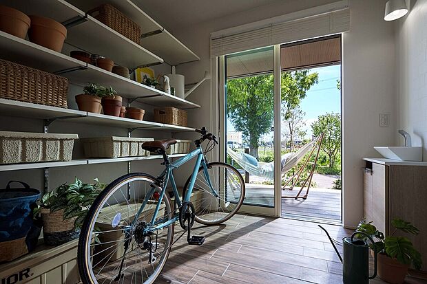 【ウッドデッキとつながる土間空間】大切なマウンテンバイクや、アウトドア用品をたっぷり収納できる止ま空間。サッシからウッドデッキのつながりがウチソト空間をゆるやかにつなげます。（2022年5月撮影。分譲済)