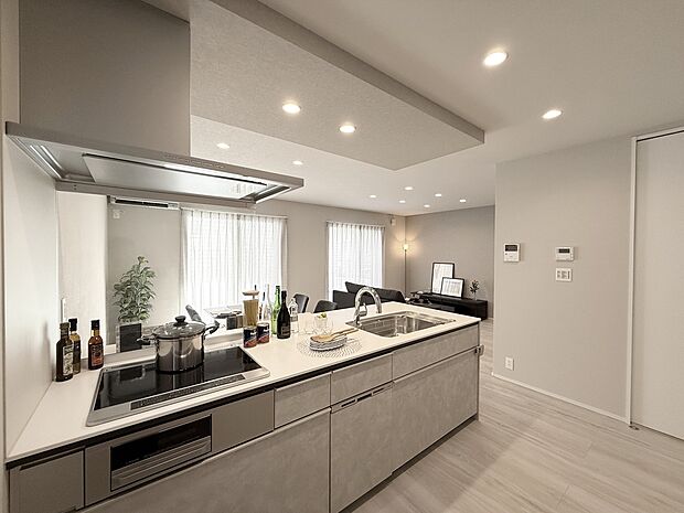 【A棟 ペニンシュラ型キッチン】広々とした天板は、調理スペースにゆとりと快適さをもたらします。かつシンクやコンロが一直線に配置されたスムーズな動線ですので、料理のしやすさを実感できるキッチンです。