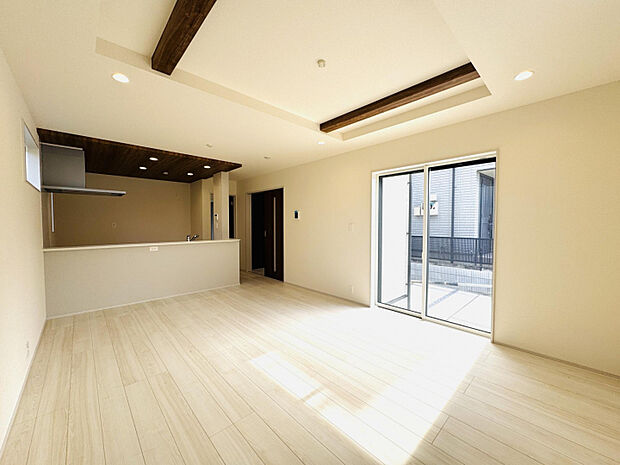 【リビング16.5帖】　建具や折上天井の梁が深い木目で統一されたすっきりとした印象の明るいリビング。