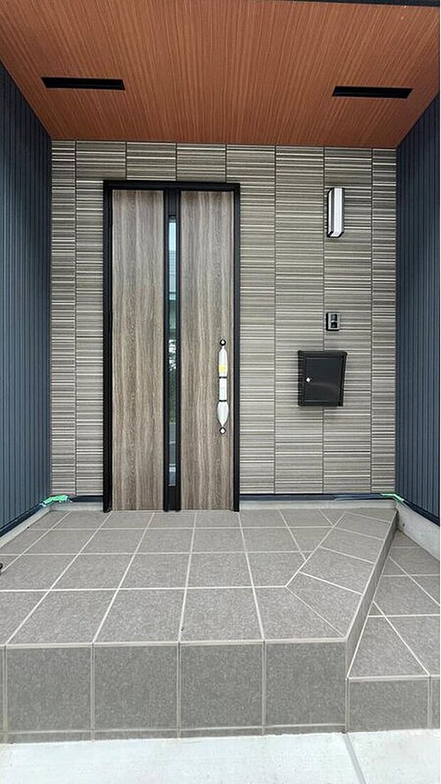 【玄関】重厚感のある石目調の玄関。扉の前は大きく屋根がかかっているので、雨の日も安心です。