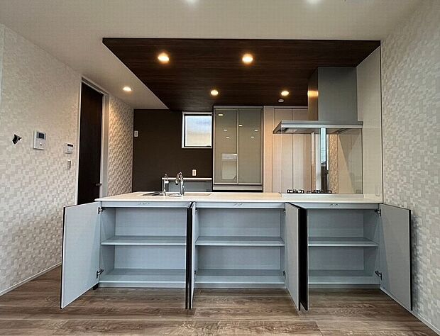 【キッチン】リビング側に便利な収納完備！普段使いのお薬やお子様のおもちゃをすぐ取り出せて便利！キッチン上部は折下天井を採用、高級感あふれるデザイン、お洒落で機能的な空間を実現します！