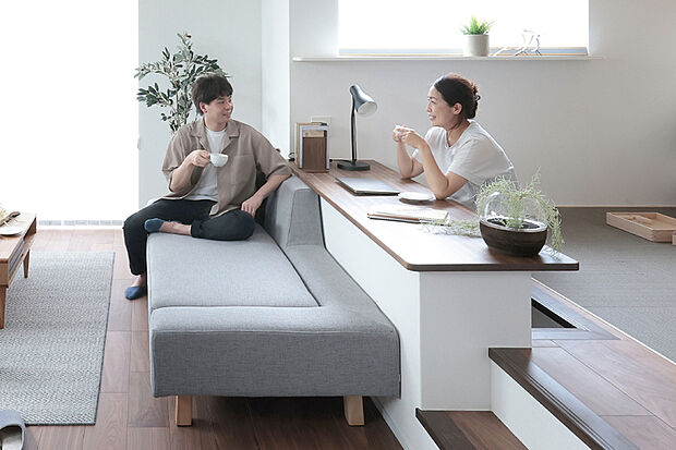 【程よい距離感が家族をつなぐステージリビング】リビングの一角を小上がりにしたステージリビング。段差により空間を緩やかに区切ることで、開放感をそのままに、一体感のある空間に。