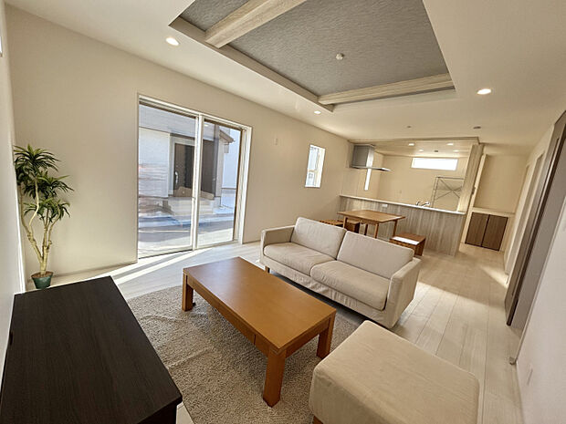 【（1）号棟】キッチン部分と折上天井の梁部分に同一の木目調のアクセントクロスでリビングに統一感を出しました　