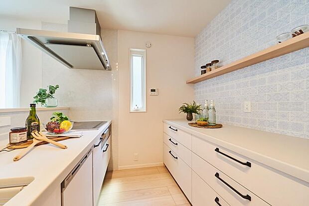 No.1_キッチン（撮影_2023年7月）ホワイトを基調とした清潔感のあるキッチンスペース。カウンター収納が標準設置済です。カウンター収納上部の壁紙も印象的な空間を演出しています。