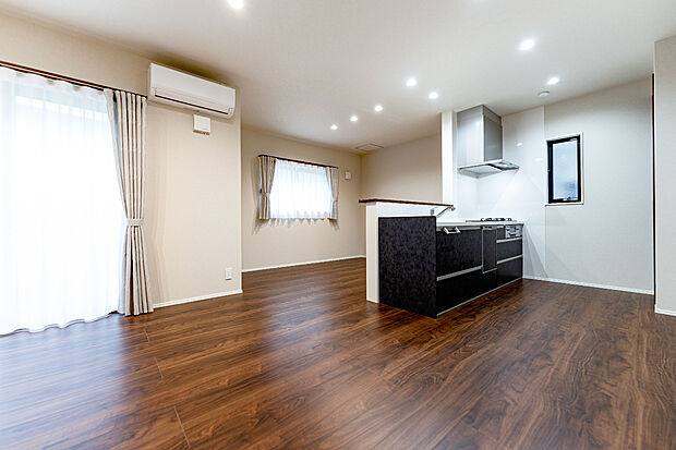 【1階約19.1帖LDK/B号地モデルハウス】ダウンライトが天井をすっきりと見せ、1階のどこにいてもご家族の気配が感じられる伸びやかな団らん空間。陽だまりが心地よく、ご家族揃ってゆったり寛ぎの時間を。