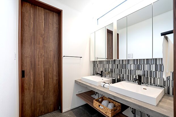 【【1階洗面室/C号地モデルハウス】】ダブルボウルのため、朝の準備もスムーズに捗ります。トーンを抑えたタイルや水栓がホテルライクな水回りに。1階ホールから直行でき、脱衣・ランドリールームへ直接繋がります。