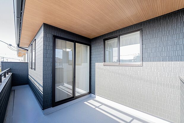 【【2階バルコニー/B号地】】2階約7.3帖主寝室から出入りができ、奥行きがあるバルコニー。木目の軒天が外観にも表情を添えています。主寝室にはWICがあり、乾いた洗濯物をそのままハンガー掛けで仕舞うことも。