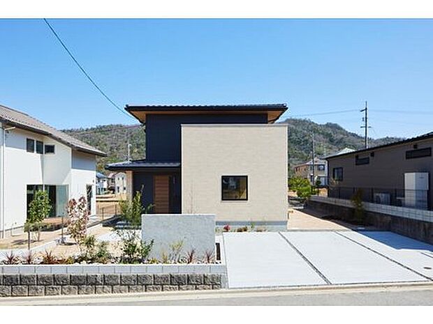 重厚感溢れる寄棟屋根の家。ベージュとブラックを掛け合わせることで、メリハリのあるモダンなイメージを演出しています。外観から優雅な暮らしを想像できるデザインです。