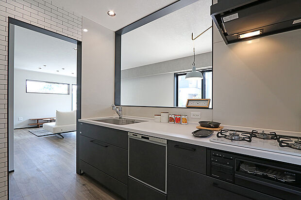 【1号棟　キッチン】吊戸棚をなくしてすっきりとしたデザインのシステムキッチン。食器洗浄乾燥機を備え、効率的に家事をこなせます。