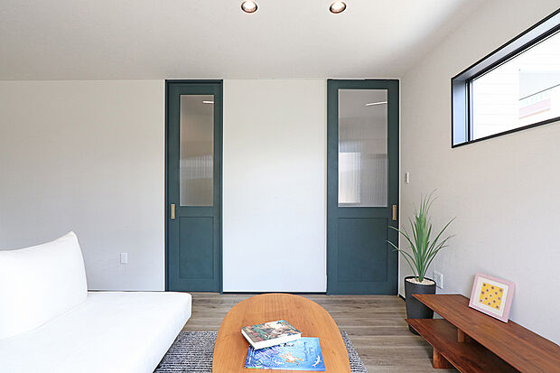 【1号棟　リビング】ダークグリーンのドアを使ったお洒落なリビング空間。落ち着きと華やかさをを演出しています。