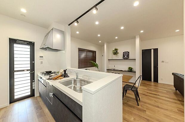 【キッチン/当社施工例】
質感のあるキッチンパネルが高級感のある印象。開放感はそのままに、調理中の手元を隠せる腰壁を設け、生活感を抑えられるよう配慮しました。