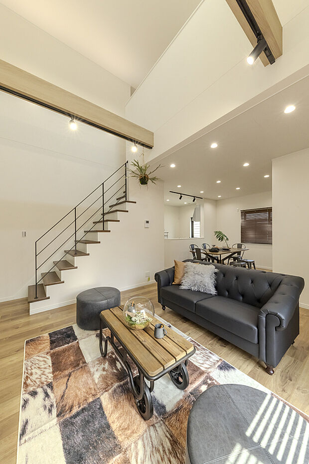 【【LDK/当社施工例】】ダイナミックな吹抜天井には見せ梁を採用し、住まいの意匠性を高めました。圧迫感を軽減するスケルトン階段との相乗効果で、より居住空間が広々と感じられます。