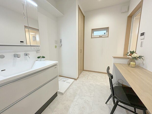 【洗面室】洗面化粧台のボウル右側は洗顔料やハンドソープなど濡れたものを置く「ウェットエリア」やタオルや眼鏡など濡らしたくないものを置く「ドライエリア」に分かれた2WAYカウンター。また、素材はお手入れしやすいアクリル人造大理石で形状もボウル一体型なので隙間がなく毎日の掃除も楽々です。デザインはシンプルかつエレガント。朝の身支度もスッキリ気持ちよくできそうです。
また脱衣室と洗面化粧室はセパレート型。同時に別の人が使用できる他、来客時は脱衣所のドアを閉めて案内できるのもポイントです。