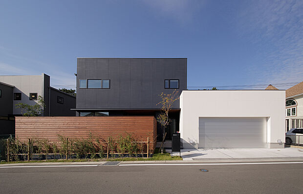 【黒と白のコントラストが美しいガレージハウス】黒と白のシンプルなボックスに木のフェンスを組み合わせた、メリハリのある外観。ビルトインガレージ付きで、デザインも暮らしやすさも叶えます。