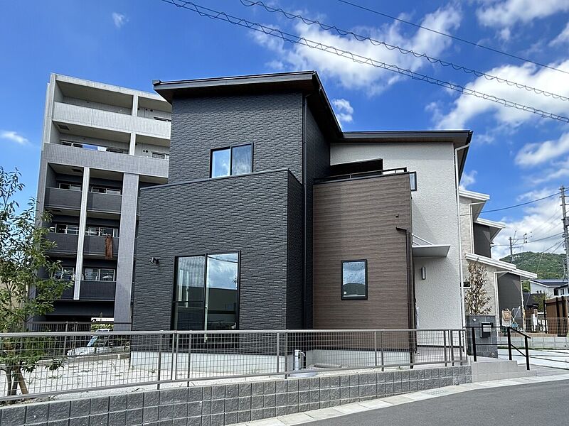 1号地の外観写真。片流れ屋根にすることで太陽光の設置面積をより多く確保しています。外構は洗い出し、目地芝詰め、ロックガーデン・タイル張り門柱などを駆使して建売らしからぬ高級感を引き出しました。