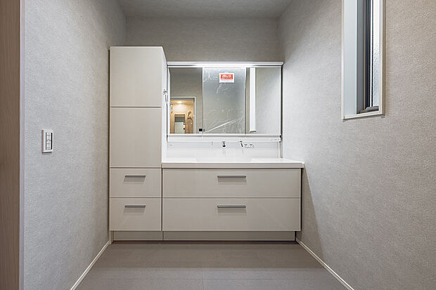 【洗面室(1号棟)】白を基調とした爽やかな洗面室。大容量の収納を備えています。