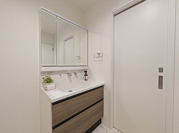 【【洗面化粧台/既分譲】】3面鏡付きの洗面化粧台です。水栓は、金具回りに水が溜まらない壁出しタイプなので、清潔さが保てそうです。手洗いボウル下にタオルなどを収納できます。