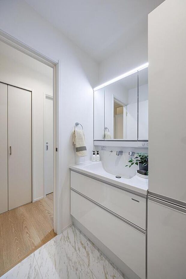 【【施工例/洗面室】】シャワー水栓＆三面鏡付きの洗面化粧台で、朝の身支度もスムーズに行えそうです。洗面台やフロア材はホワイトを基調としており、清潔感のある空間を演出します。