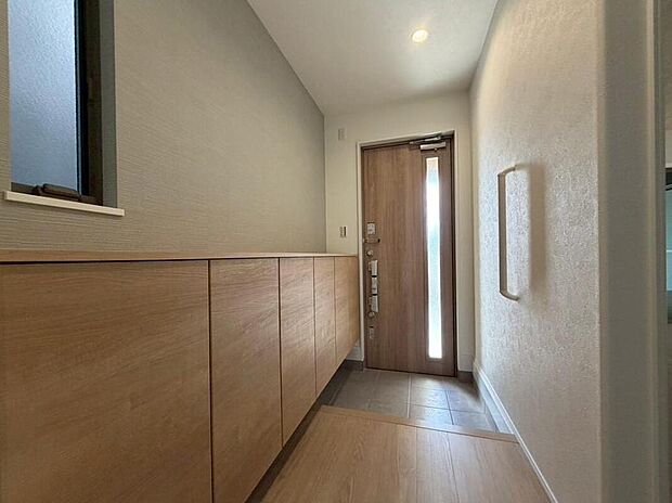 【【玄関/No.3】】2方に採光を確保しており、自然光が届く明るい玄関スペースです。ワイドサイズのシューズボックスを備えており、ご家族の履き物をたっぷりと収納できます。