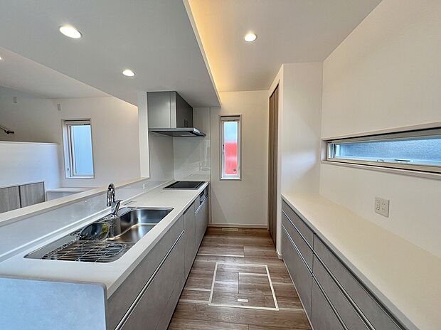 【キッチン/2号棟】
明るく開放的なキッチンです。背面にはデザインを統一したカップボードを設置しております。奥にはパントリーもあるので、食品や日用品をストック可能です。/2025年8月撮影