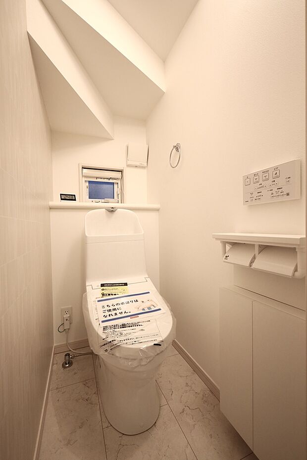 【【トイレ/2号棟】】トイレは1階と2階に配置しております。トイレットペーパーホルダーの下部には収納があり、お掃除道具をすっきりとしまっておけます。※未入居住宅