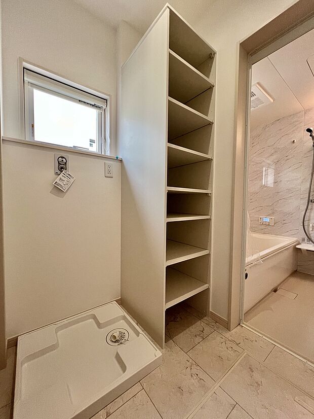 【【リネン庫/2号棟】】洗面と脱衣室を分離しているため、ご家族の入浴中も気にせず洗面台をお使いいただけます。脱衣室にはリネン庫を設けており、タオルや衣類を収納可能です。/2025年8月撮影