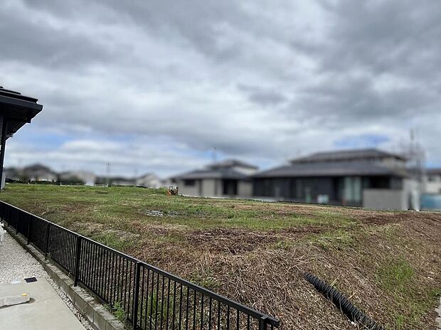 【現地写真】フェンス側から撮影しており、隣地との境界や敷地形状が確認できます。外構計画を考える際の参考にもなります。