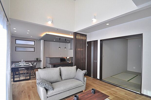 【リビング】19帖のLDKは床暖房付き。吹抜けが心地よい採光と開放感を生み、ソファ越しにダイニングまで広がる上質な空間です。