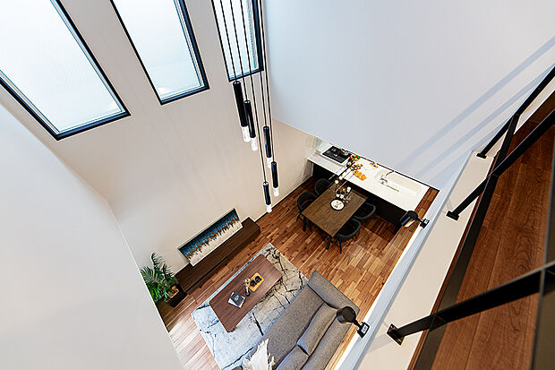 【【弊社施工例／吹抜から見るLDK】】邸宅には大きな吹抜を設けているため、リビングに開放感が生まれ爽快な印象に。１階と２階に居ながら、家族の温もりを感じられるのも嬉しいポイント。