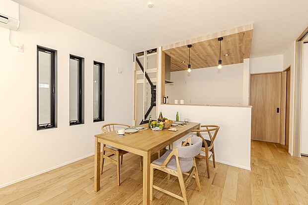 【【当社施工例/LDK】】キッチンには床材と同様の木目調のポップアップ天井を施し、統一感を感じられる空間に。ご家族との会話を楽しみながら、様子を見守りながら家事をすることができる対面式キッチンを採用しています。