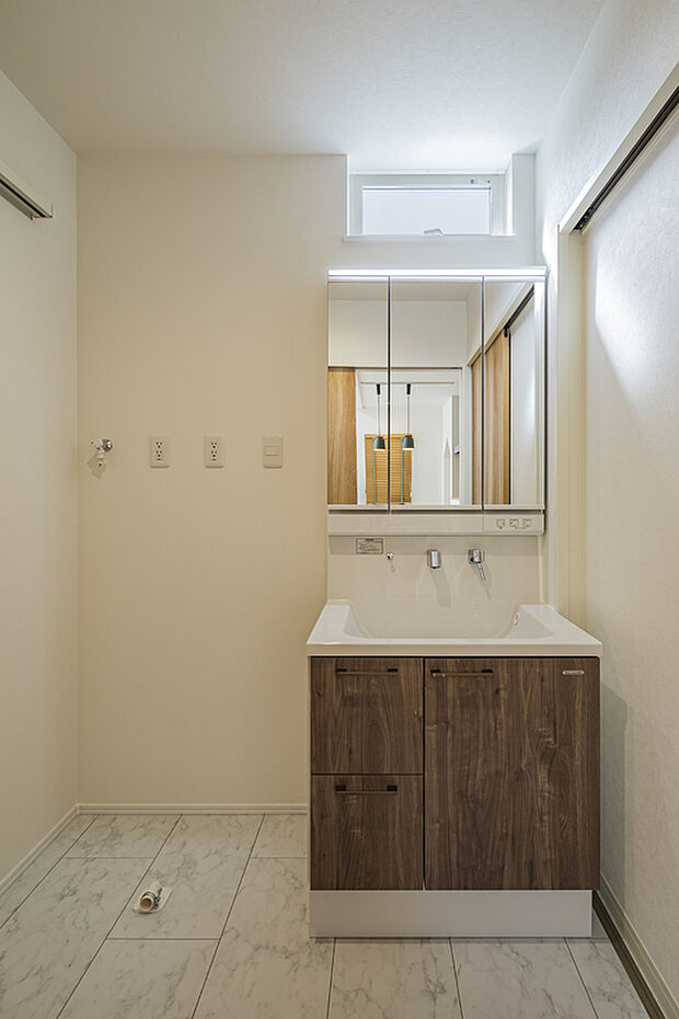 【【洗面室/当社モデルハウス】】木目調の洗面化粧台は、家具のようなお洒落な雰囲気。ボウル下の収納スペースに化粧品やタオルなどをすっきりと収納可能です。窓があり、自然光を採り込めます。