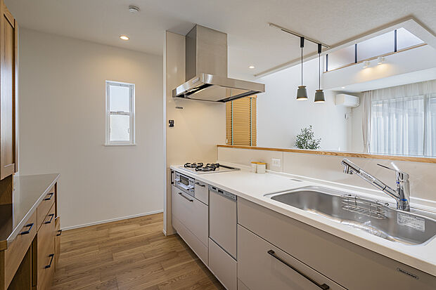 【【7号地モデルハウス/キッチン】】リビング全体を見渡せるアイランドキッチン。ご家族やゲストと一緒にお料理を楽しめます。キッチン前面に腰壁が施され、シンク廻りが散らかっていても、気になりにくい仕様です。