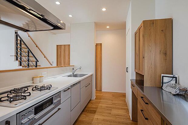 【【7号地モデルハウス/キッチン】】キッチンの下の収納はスライド式なので、奥にしまった大型の鍋類などが取り出しやすい仕様。背面のパントリーは食料品・水のストック収納や食器棚として利用できます。