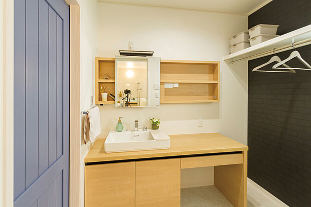 【当社施工例】明るい洗面台はボウルサイドにもゆとりがあり、朝の支度もスムーズです。日々の動線を妨げない位置にハンガーパイプを備えており、室内干しやスチームアイロン掛けなどの際にも便利です。