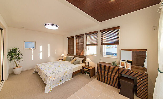 【【当社施工例】】デザイン性の高い4連の小窓を設けた主寝室です。寝具にドレッサーも置けるゆとりのあるスペースがございます。折り上げ天井がさらに開放感と高級感を演出してくれます。