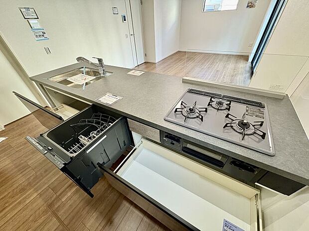 【【キッチン/2号棟】】食器洗乾燥機と浄水器付きのシステムキッチンです。食後の洗い物の時間が短縮できるので、ゆっくりと家族団らんを楽しめます。グリル付きの3口コンロで、複数調理が同時に可能です。