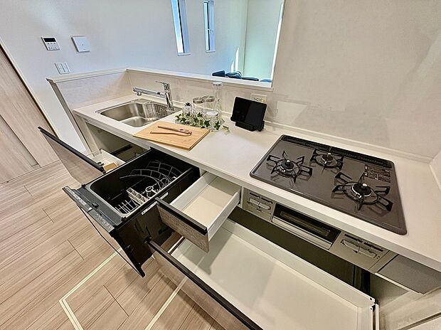 【【キッチン】】家事負担を軽減する食器洗乾燥機が備わっています。グリル付きの3口コンロで、複数調理が同時に可能です。シンクやコンロ下に収納があり、作業スペースを広く確保できます。